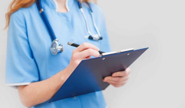 Female doctor writes notes on the clipboard Female doctor writes notes on the clipboard